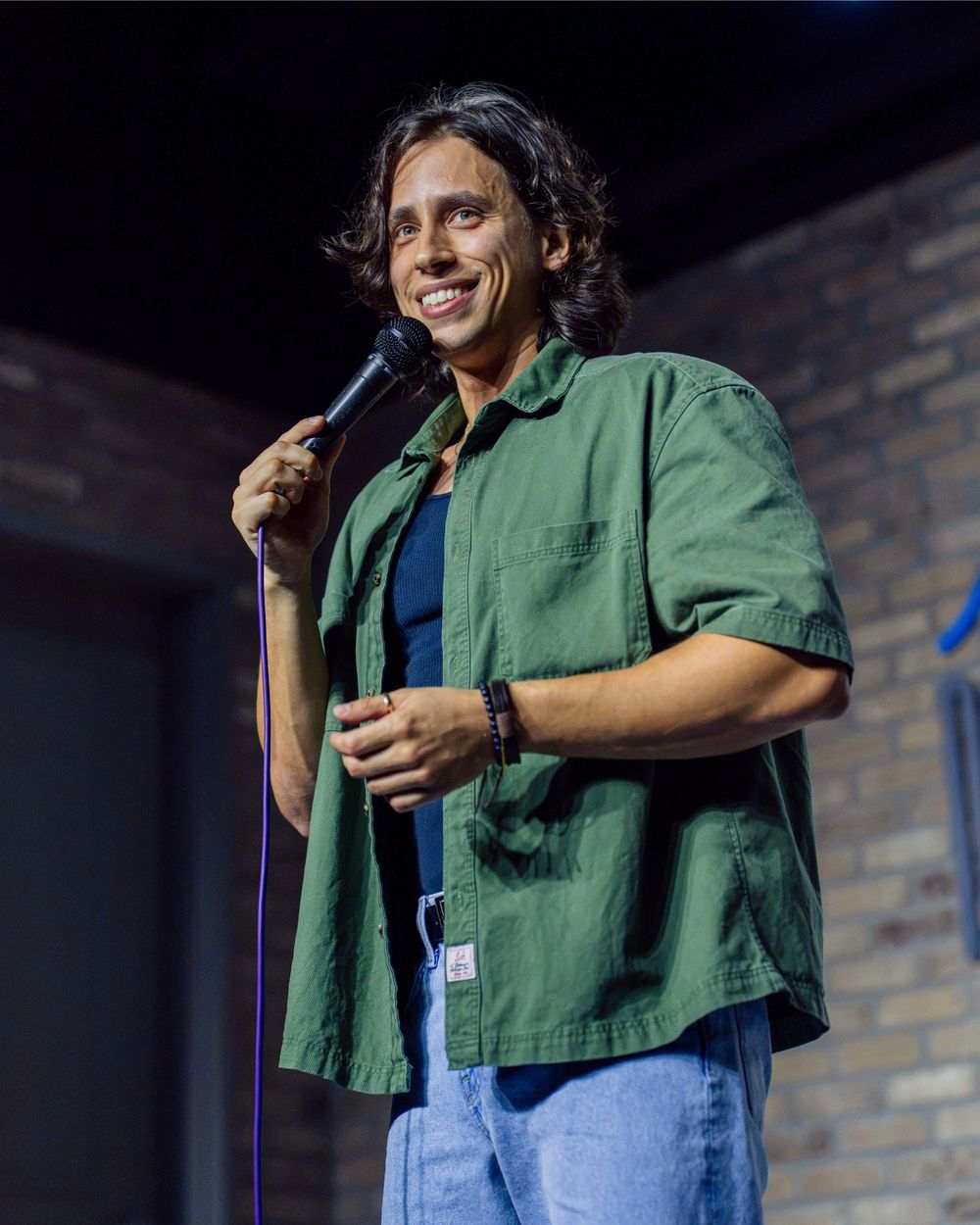 Lando Gonzalez smiling on stage with a microphone